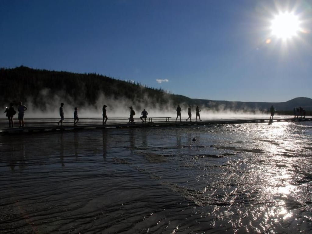 Auf Plankenwegen kommen Besucher der heißen Quelle Grand Prismatic Spring in Yellowstone sehr nahe. Foto: Christian Röwekamp