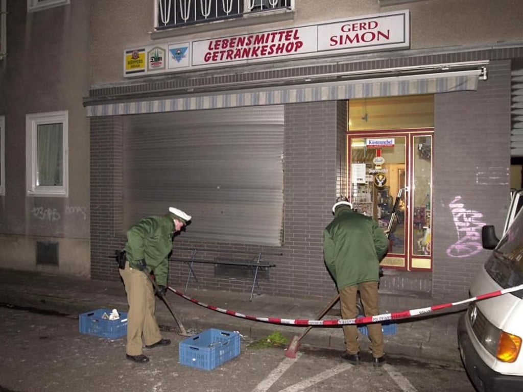 Nach einen Bombenanschlag des NSU auf ein Lebensmittelgeschäft in der Kölner Probsteigasse untersuchen Polizisten den Tatort. Foto: Henning Kaiser/Archiv