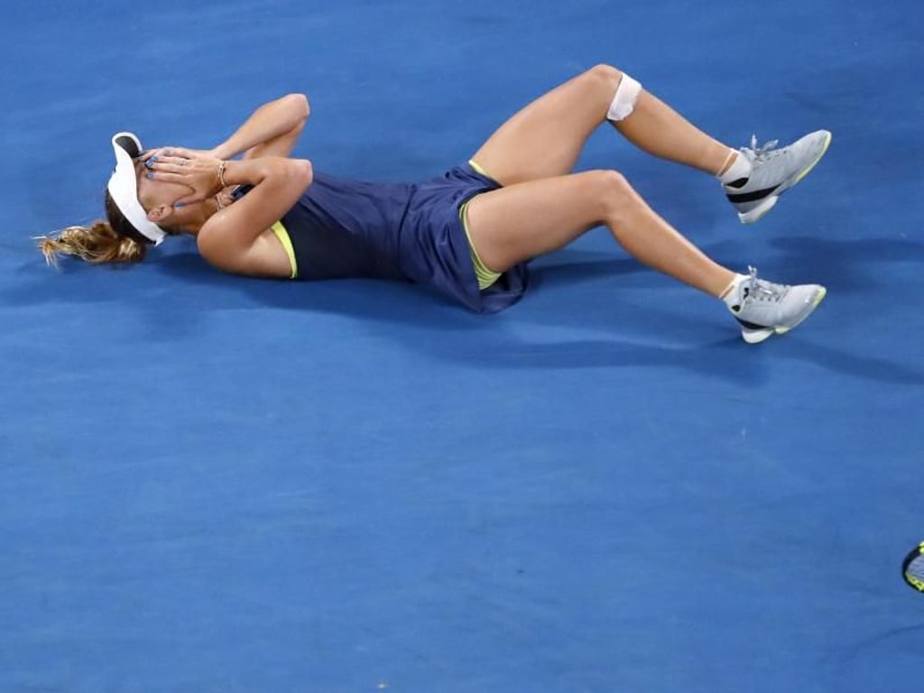 Wozniacki liegt nach ihrem Sieg mit den Händen vor dem Gesicht auf dem Platz. Foto: Ng Han Guan