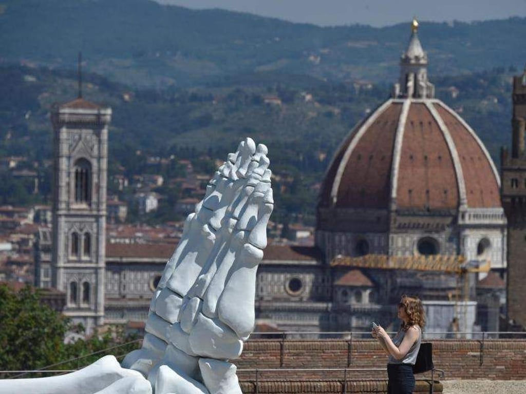 Der Füße des Riesenskeletts «Calamita Cosmica» auf der Festung Forte di Belvedere mit Blick auf die Kathedrale Santa Maria del Fiore. Foto: Maurzio Degl'indolenti