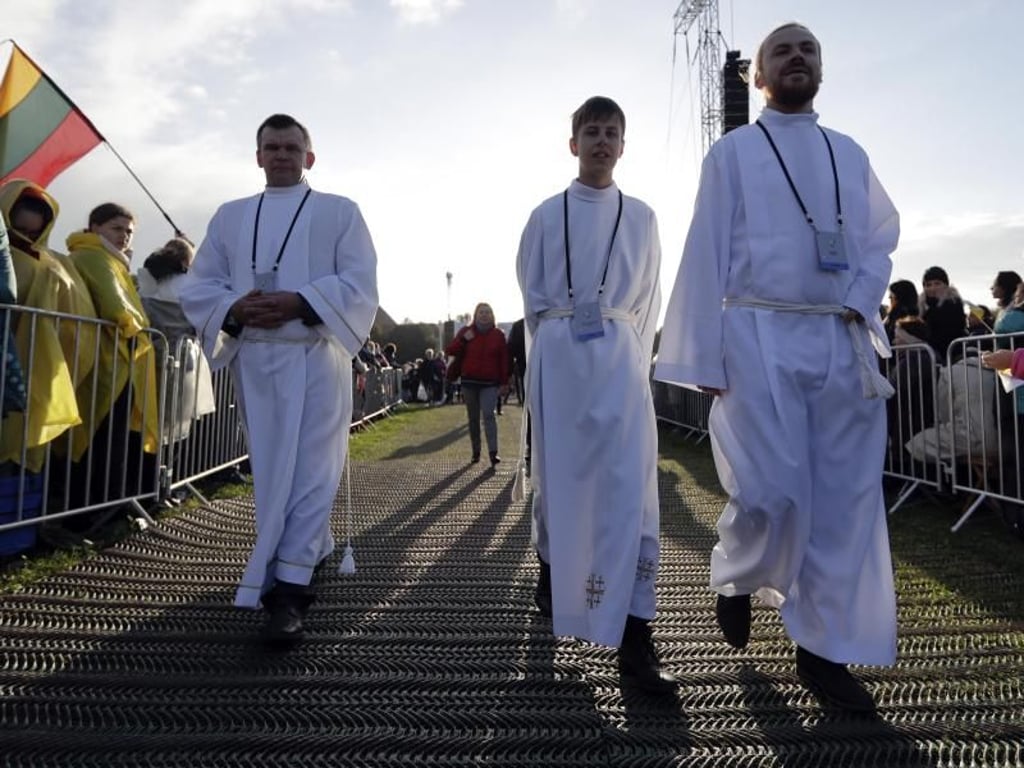Priester nehmen ihre Positionen für die Freiluftmesse ein. Foto: Andrew Medichini/AP