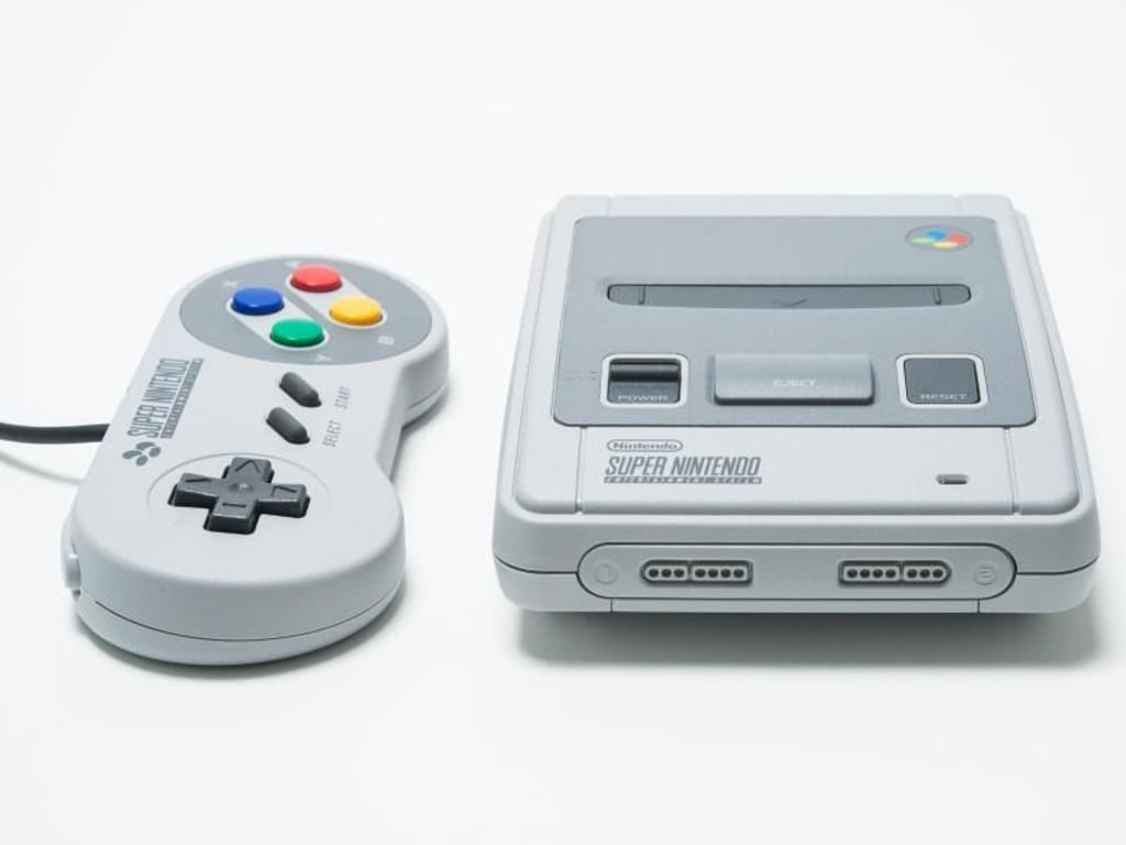 Hinter der Klappe an der Vorderseite des Super Nintendo Classic Mini stecken die Anschlüsse für die Controller, der Steckplatz für die Spielmodule ist nur Verzierung. Foto: Franziska Gabbert/dpa-tmn