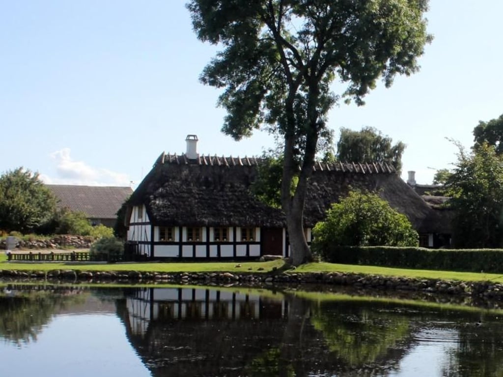 Fachwerkhäuser spiegeln sich im Dorfteich: Nur im Hochsommer herrscht auf der kleinen Insel Lyø Betrieb. Foto: Bernd F. Meier
