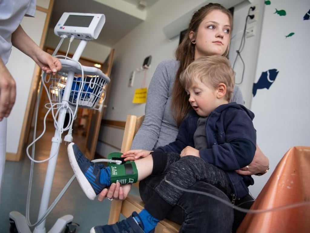 Eine Pflegerin misst Levins Blutdruck. Seine Mutter Lea rettete ihm mit einer Stammzellenspende das Leben. Foto: Marijan Murat