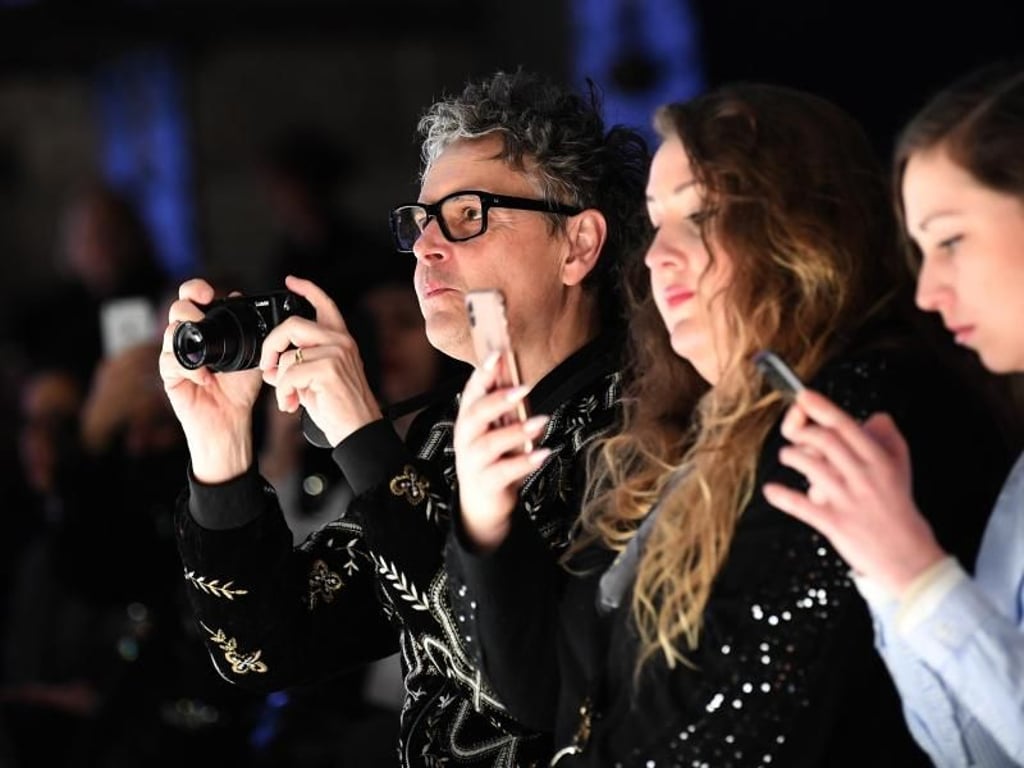 Casting Director Rolf Scheider (GNTM) reicht das Handy bei der Show von Irene Luft nicht. Foto: Britta Pedersen