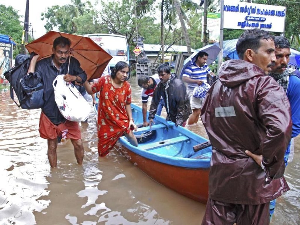 Flutopfer werden von Helfern evakuiert. Foto: K. Shijith/AP