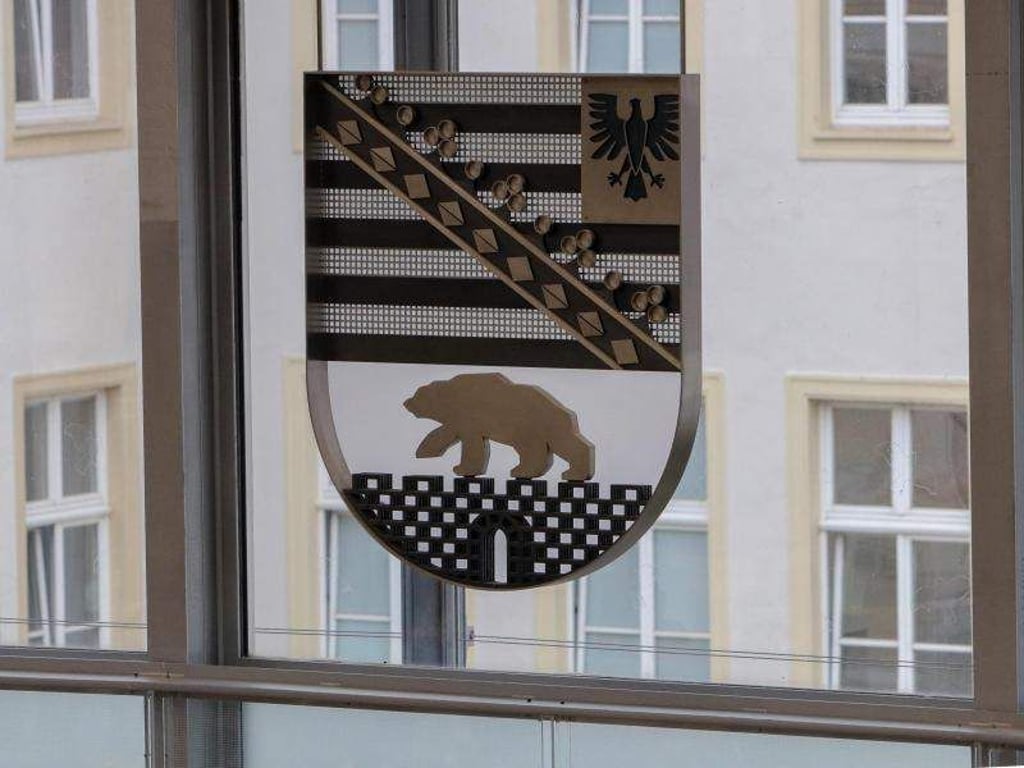 Das Wappen von Sachsen-Anhalt hängt an der Fensterfront im Plenarsaal des Landtages. Foto: Peter Förster/Archiv