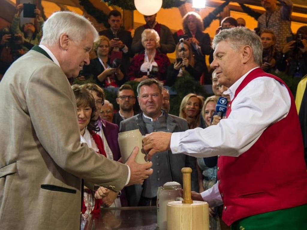 Der Münchner Oberbürgermeister Dieter Reiter (r, SPD) überreicht die erste Maß Bier dem bayerischen Ministerpräsidenten Horst Seehofer (l, CSU). Foto: Peter Kneffel