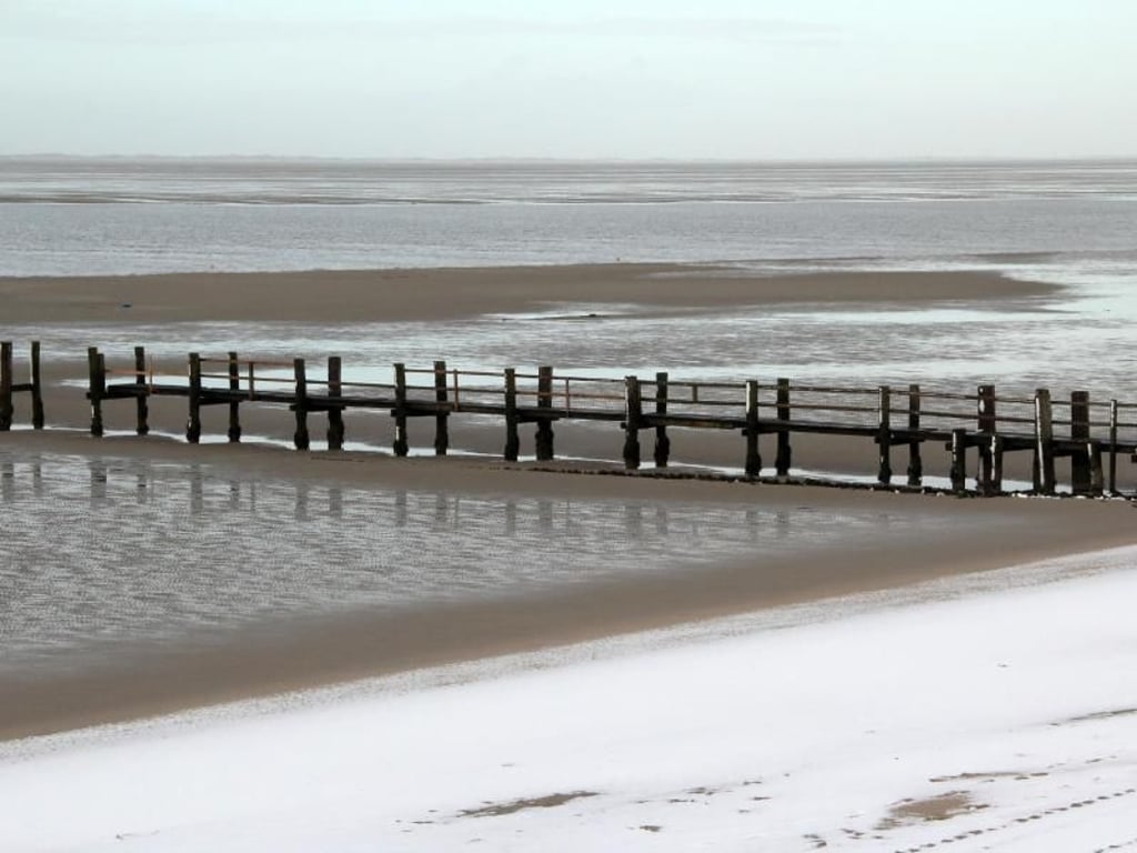 Badewetter herrscht nicht: Dafür können Besucher am Strand bei Utersum im Schnee spazieren. Foto: Verena Wolff