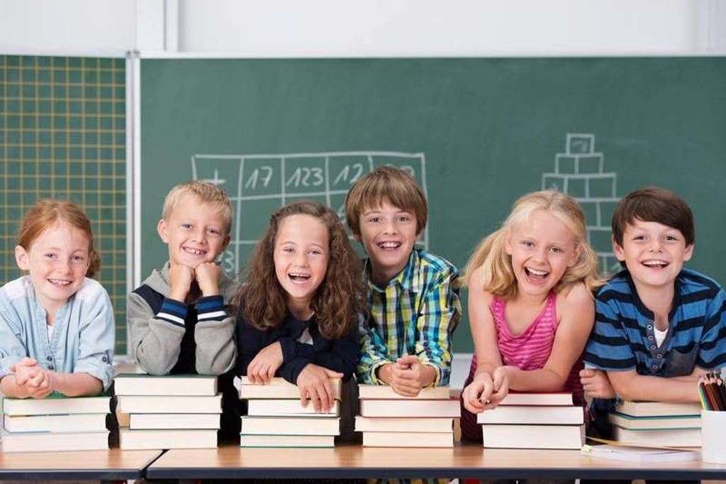 lachende kinder stützen sich auf schulbücher
