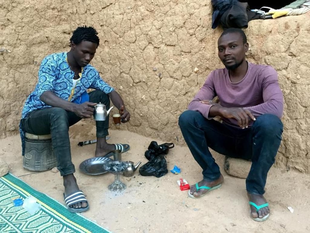 Migranten warten in einem Ghetto der nigrischen Stadt Agadez, einem Umschlagpunkt für Flüchtlinge, auf die Weiterreise nach Libyen. Foto: Kristin Palitza