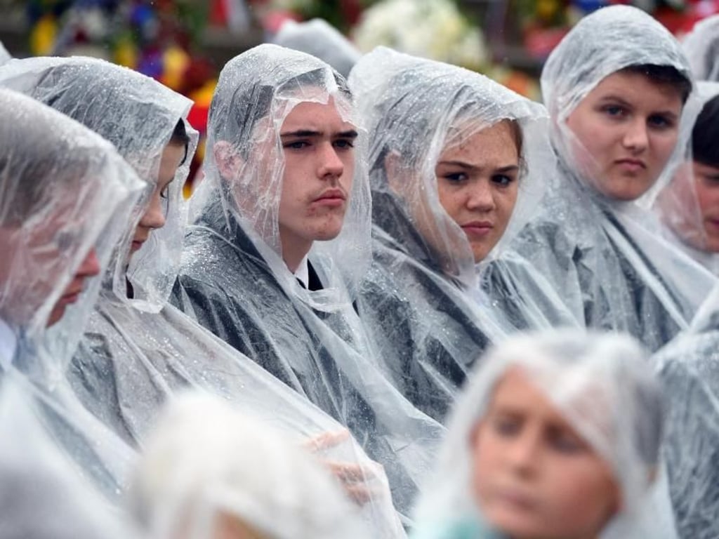 Jugendliche schützen sich gegen den australischen Regen. Foto: Mick Tsikas