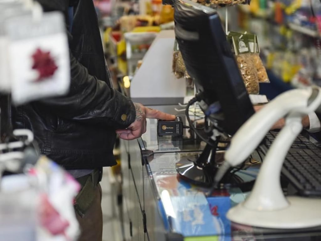 Ein Mann identifiziert sich mit seinem Fingerabdruck in einer Apotheke in Montevideo. Foto: Matilde Campodonico