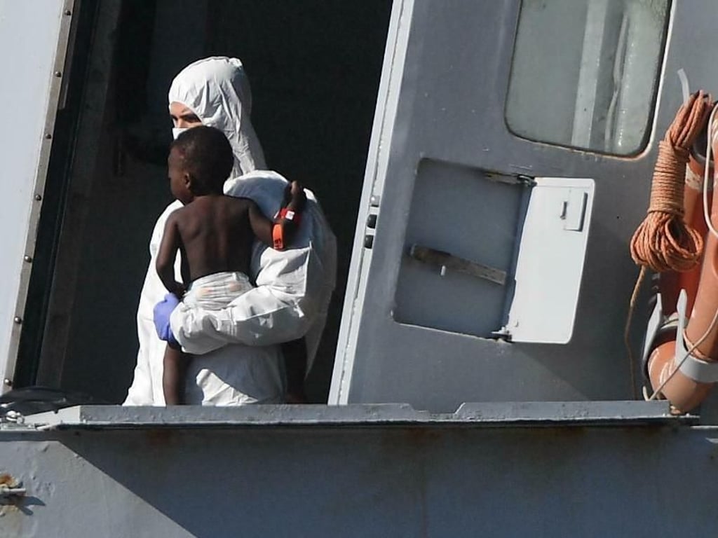 Ein Helfer bringt ein kleines Kind in Genua an Land: Leben retten soll in Italien künftig mit hohen Geldstrafen geahndet werden. Foto: Luca Zennaro/ANSA/AP