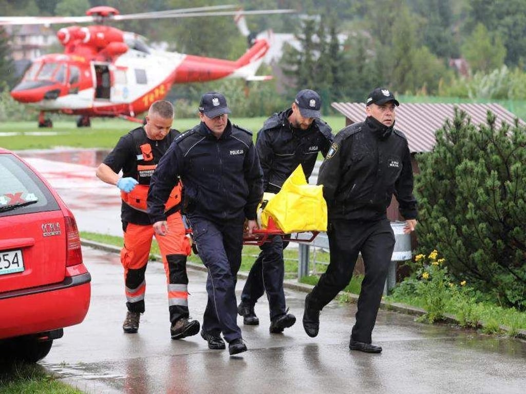 Polizisten tragen in Zakopane einen verletzten Touristen zu einem Krankenwagen. Foto: Grzegorz Momot/PAP