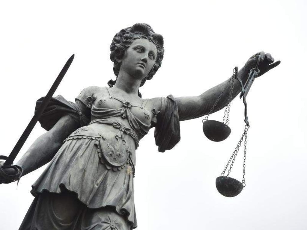 Eine Bronzestatue der Justitia steht in Frankfurt am Main. Foto: Arne Dedert/Archiv