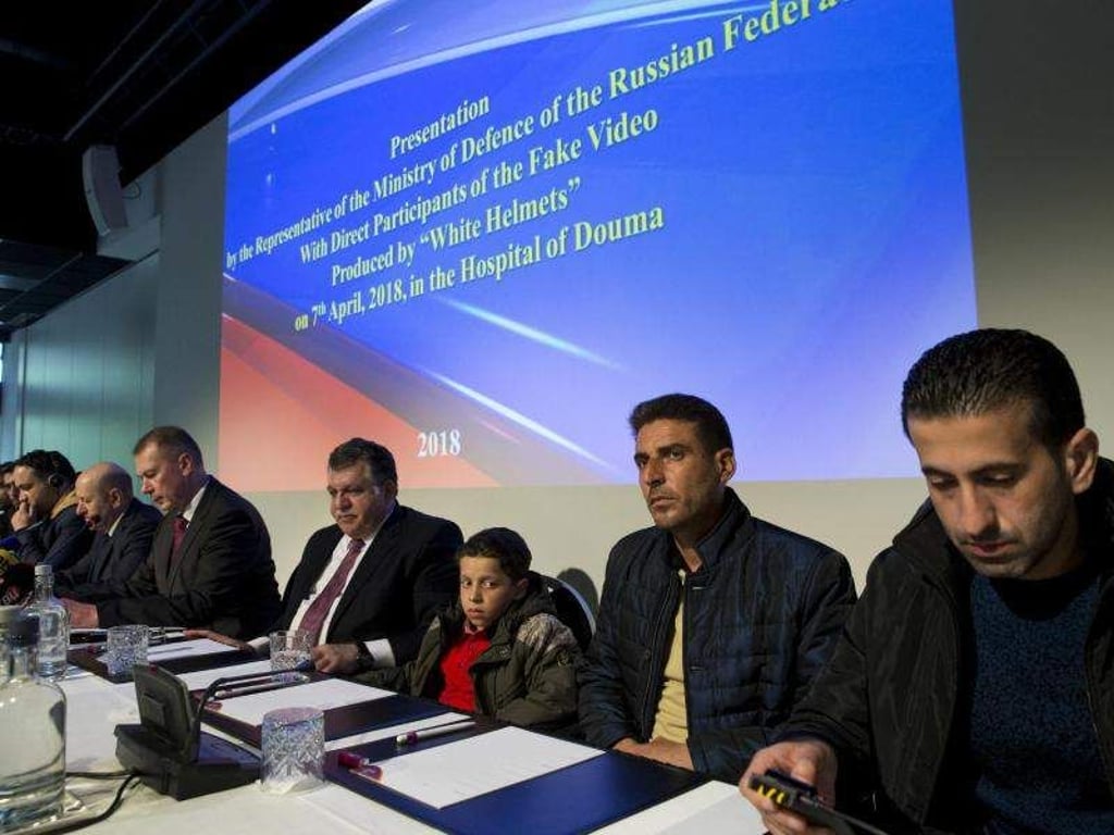 Mehrere der Syrer, die von Russland als vermeintliche Zeugen präsentiert wurden, nehmen in Den Haag an einer Pressekonferenz teil. Foto: Peter Dejong/AP