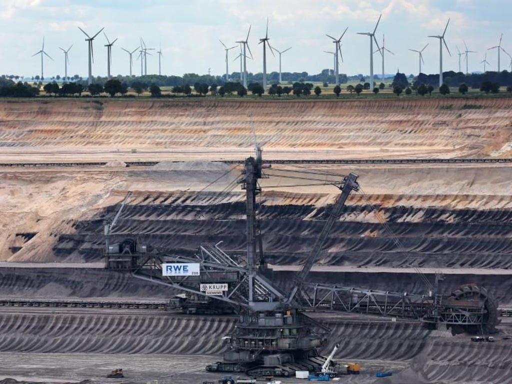Braunkohlebagger im Tagebau Garzweiler, dahinter sind Windräder zu sehen. Foto: Oliver Berg