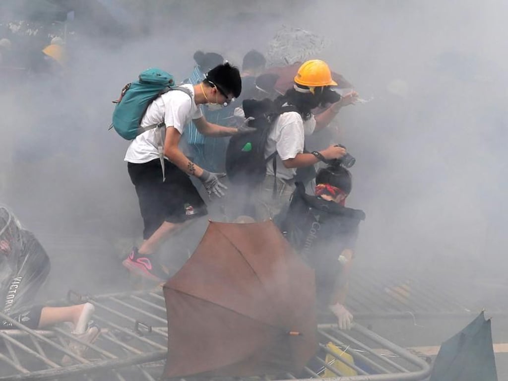 Demonstranten schützen sich mit Gesichtsmasken vor dem Tränengas der Hongkonger Sicherheitskräfte. Foto: Kin Cheung/AP