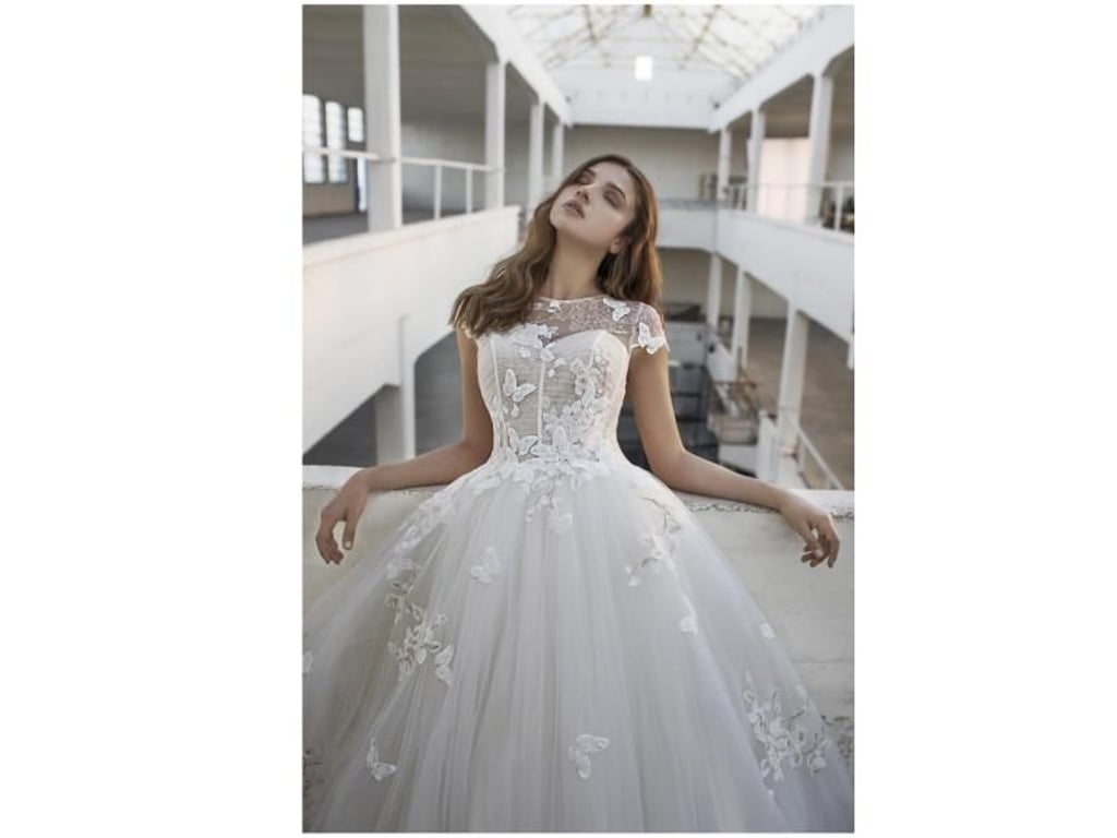 Die filigranen Blumen und Schmetterlinge fallen erst beim näheren Hinsehen auf: das elfenbeinfarbige Kleid stammt aus dem Haus Modeca (Preis auf Anfrage). Foto: Alexander Lipkin/Modeca