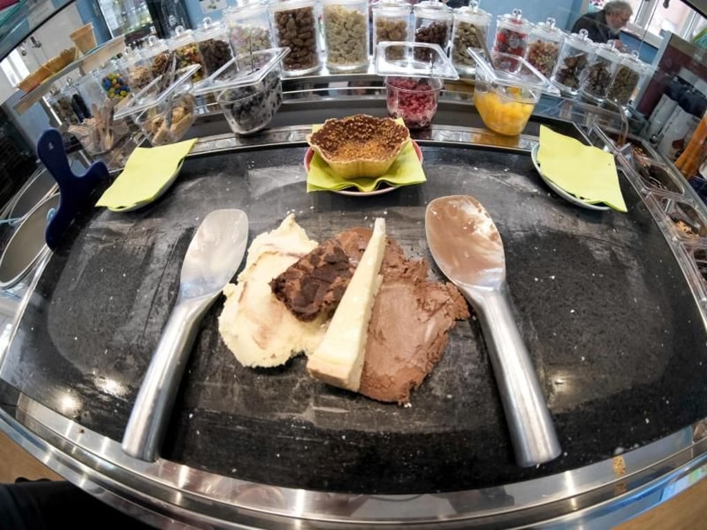 Käsekuchen, Schokokeks und Vanille- und Schokoladeneis liegen in der Hamburger Eisdiele «Schlecks» auf einem kalten Stein bereit, um zu einer Eiskugel geformt zu werden. Foto: Axel Heimken