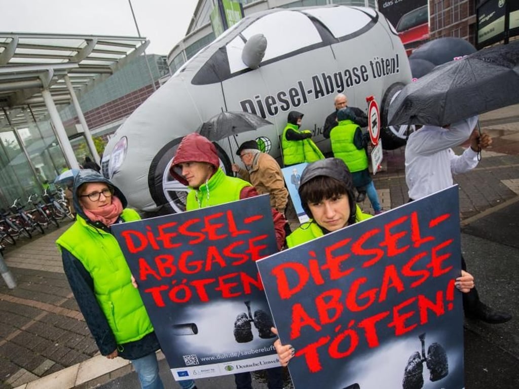 Mitglieder der Deutschen Umwelthilfe protestieren in Frankfurt mit Plakaten gegen den Dieselskandal. Foto: Andreas Arnold