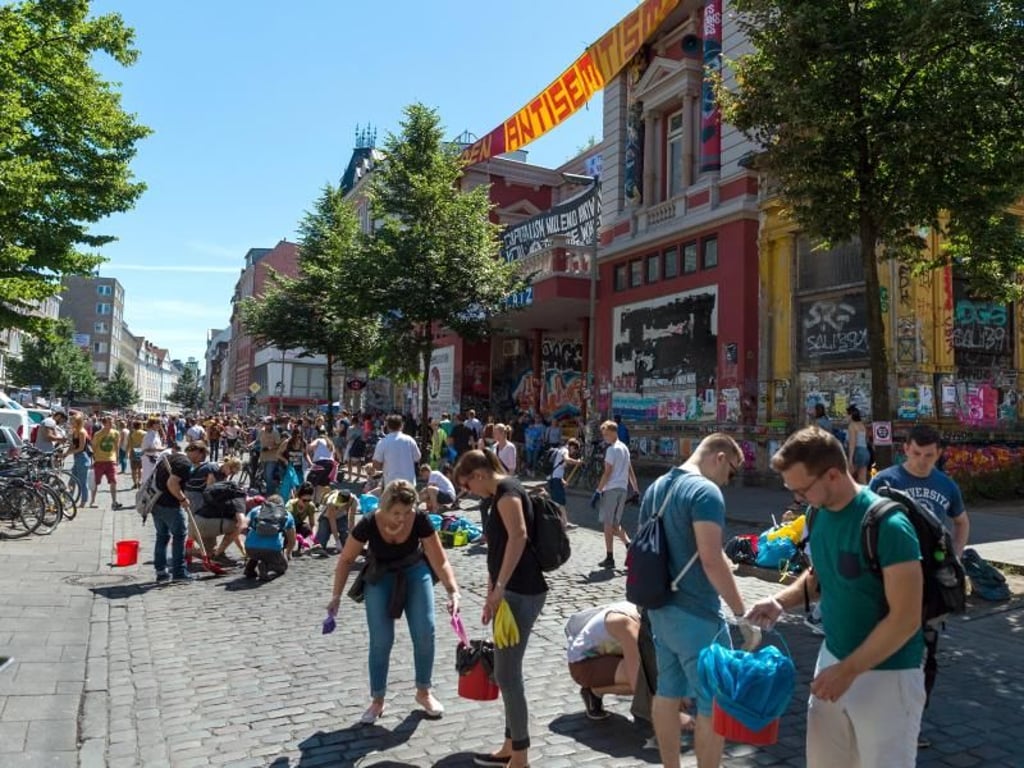 Bewohner räumen in Hamburg vor der Roten Flora die Straße auf. Foto: Christophe Gateau