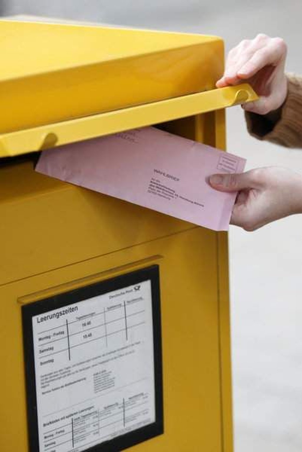 ILLUSTRATION - Eine Passantin steckt ihre Briefwahlunterlagen zur Wahl des 18. Deutschen Bundestages am 12.09.2013 in einen Briefkasten in Hamburg. Foto: Bodo Marks/dpa +++(c) dpa - Bildfunk+++