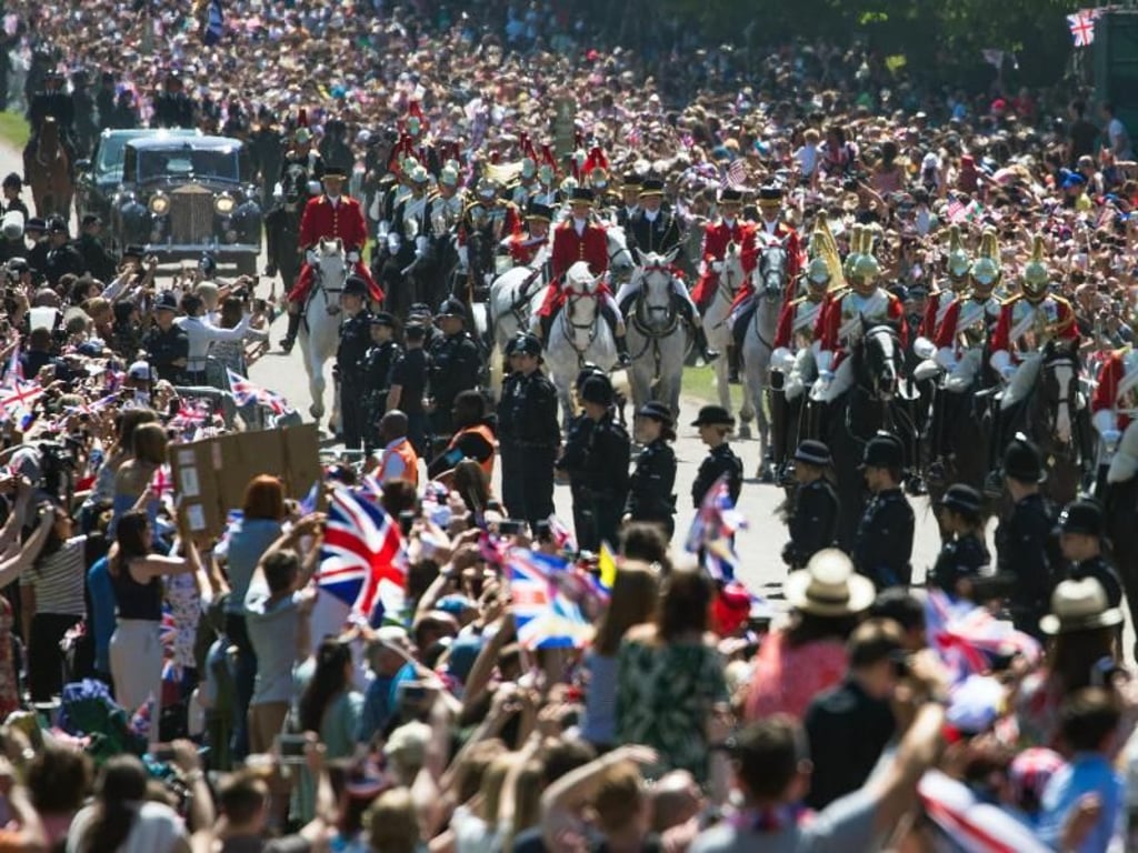 Zehntausende säumen den Long Walk und verfolgen begeistert die Kutschfahrt von Harry und Meghan. Foto: Peter Dejong/AP