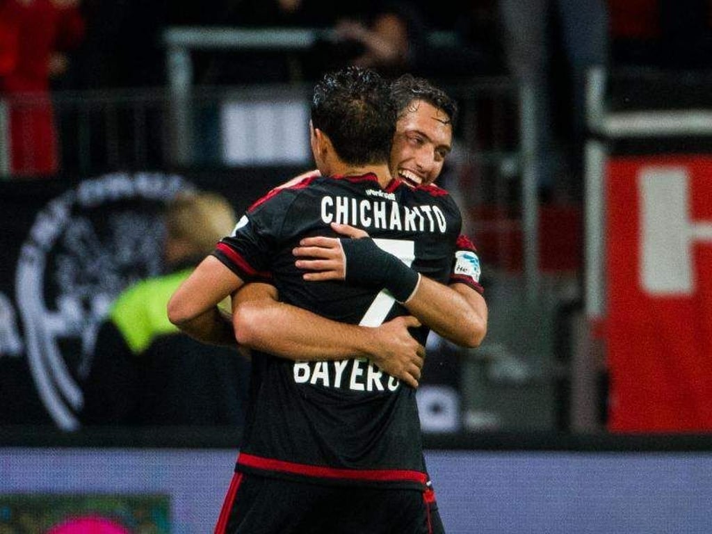 Chicharito (l) freut sich mit Hakan Calhanoglu über den Treffer zum 1:0-Sieg. Foto: Rolf Vennenbernd