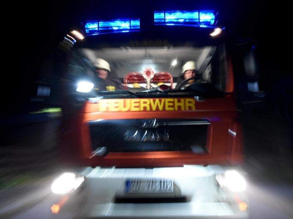 Männer der Feuerwehr sitzen in einem Löschfahrzeug. Foto: Carsten Rehder/Archiv
