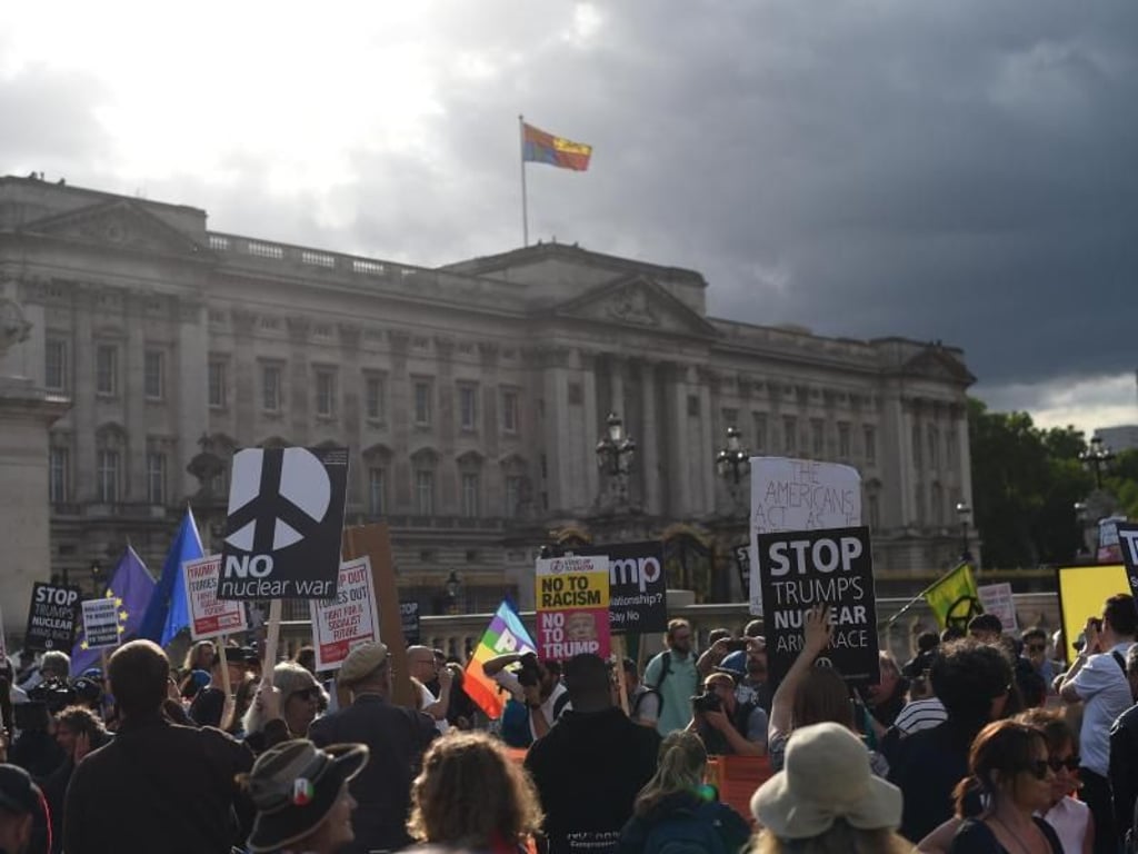 Gegner von US-Präsident Trump protestieren mit Schildern vor dem Buckingham Palast. Foto: David Mirzoeff/PA Wire