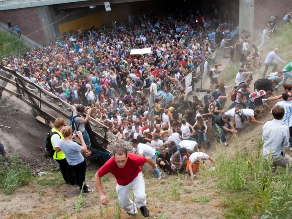 Tausende Menschen drängen sich bei der Loveparade 2010 in und vor dem Tunnel, in dem sich die tödliche Massenpanik ereignete. Foto: Erik Wiffers