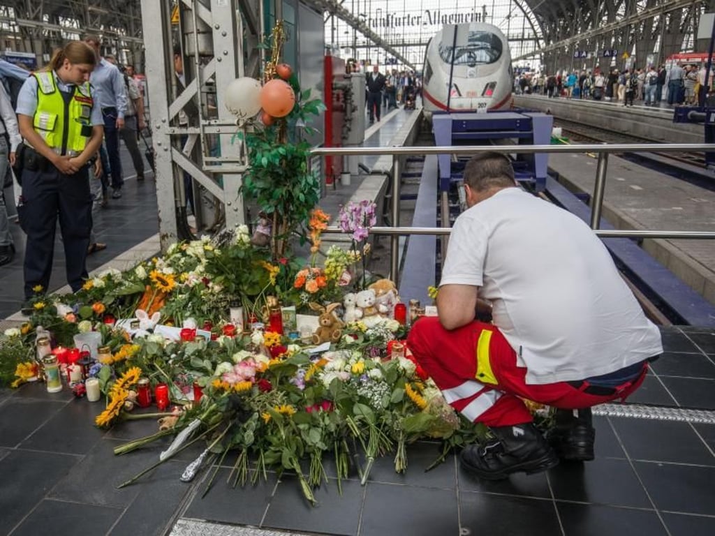 Ein Ersthelfer, der am Tag zuvor vor Ort war, legt am Bahnsteig 7 im Frankfurter Hauptbahnhof Blumen nieder. Foto: Frank Rumpenhorst