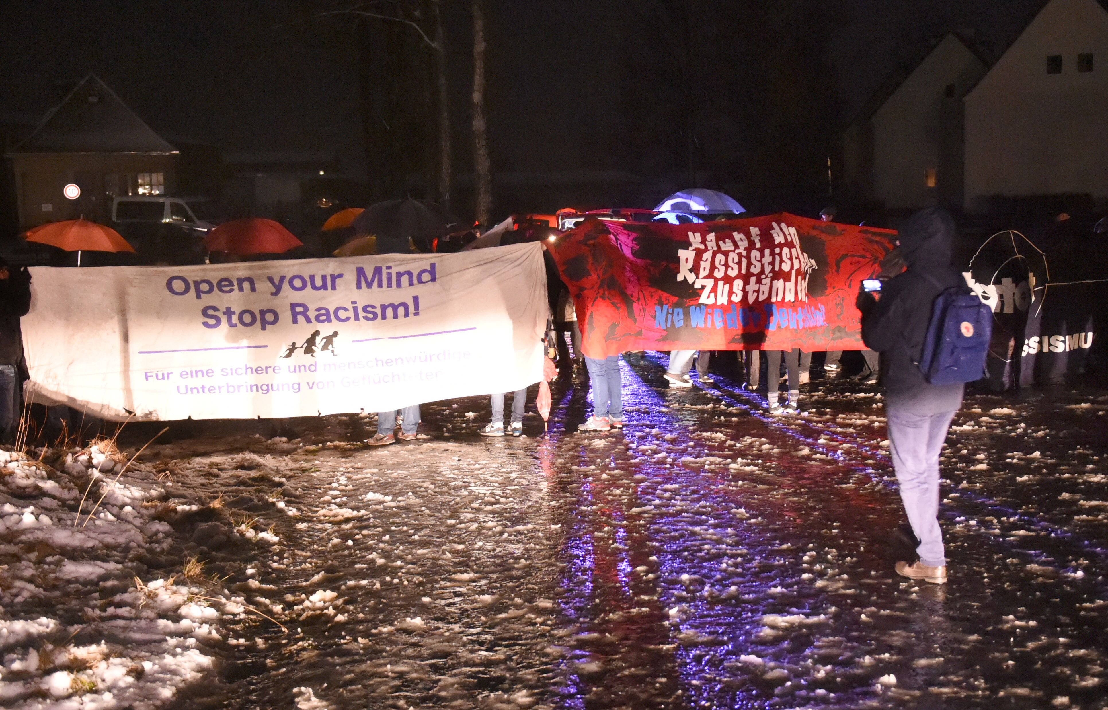 "Open your mind - stop racism" steht auf Plakaten, die bei einer Demo in Clausnitz gehalten werden.