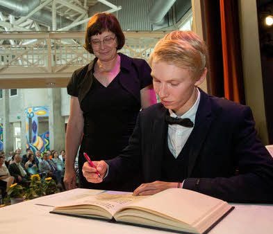 Als bester Abiturient des Jahrgangs mit einem Notendurchschnitt von 1,0 durfte sich Till Lossin im Beisein von Monika Kaufhold ins Ehrenbuch des Gymnasiums eintragen.