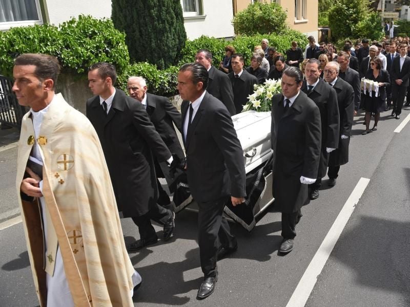 Die Trauergemeinde folgt Dechant Wolfgang Picken (l) und dem Sarg zum Friedhof. Foto: Henning Kaiser