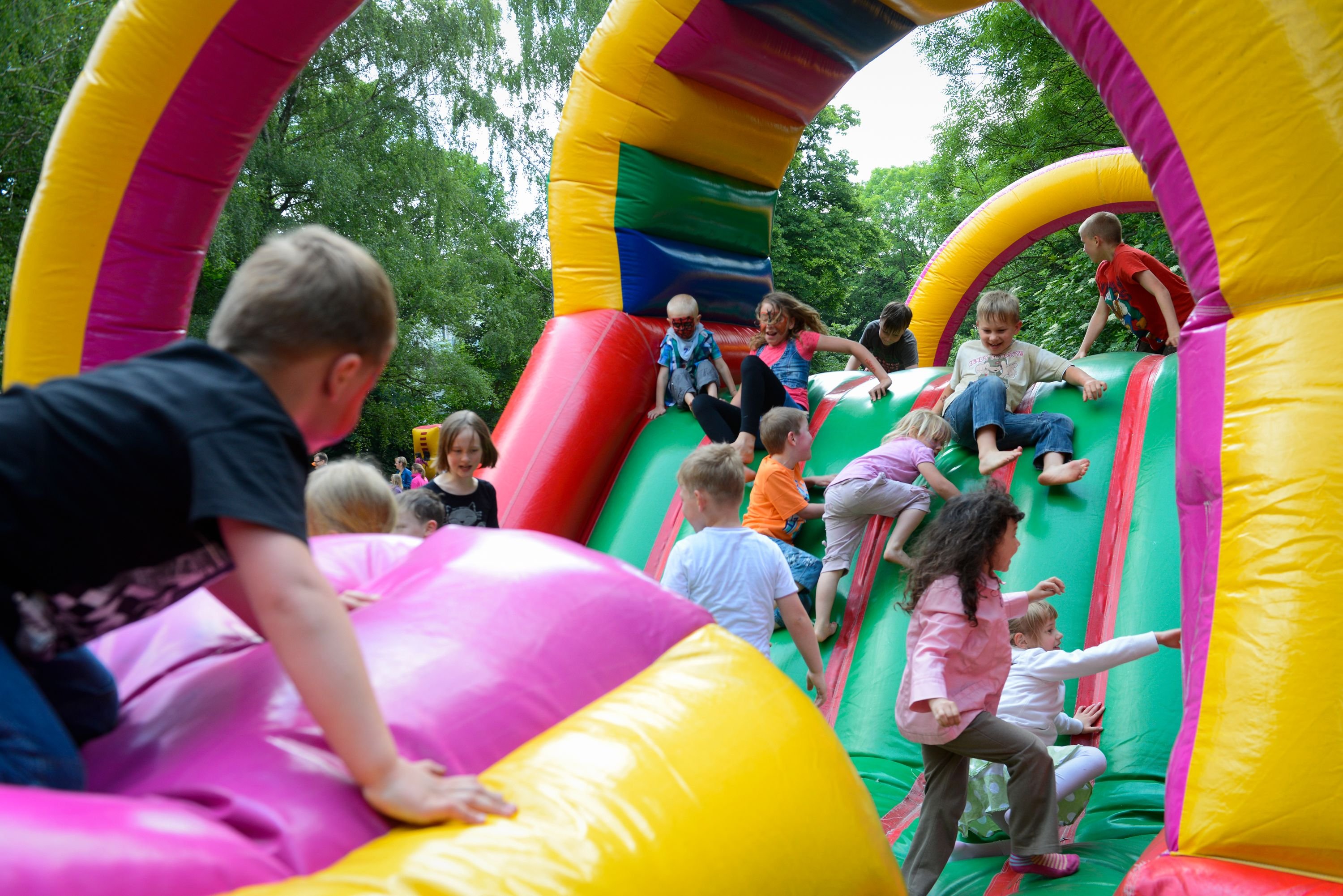 Kinder springen auf einer Hüpfburg.