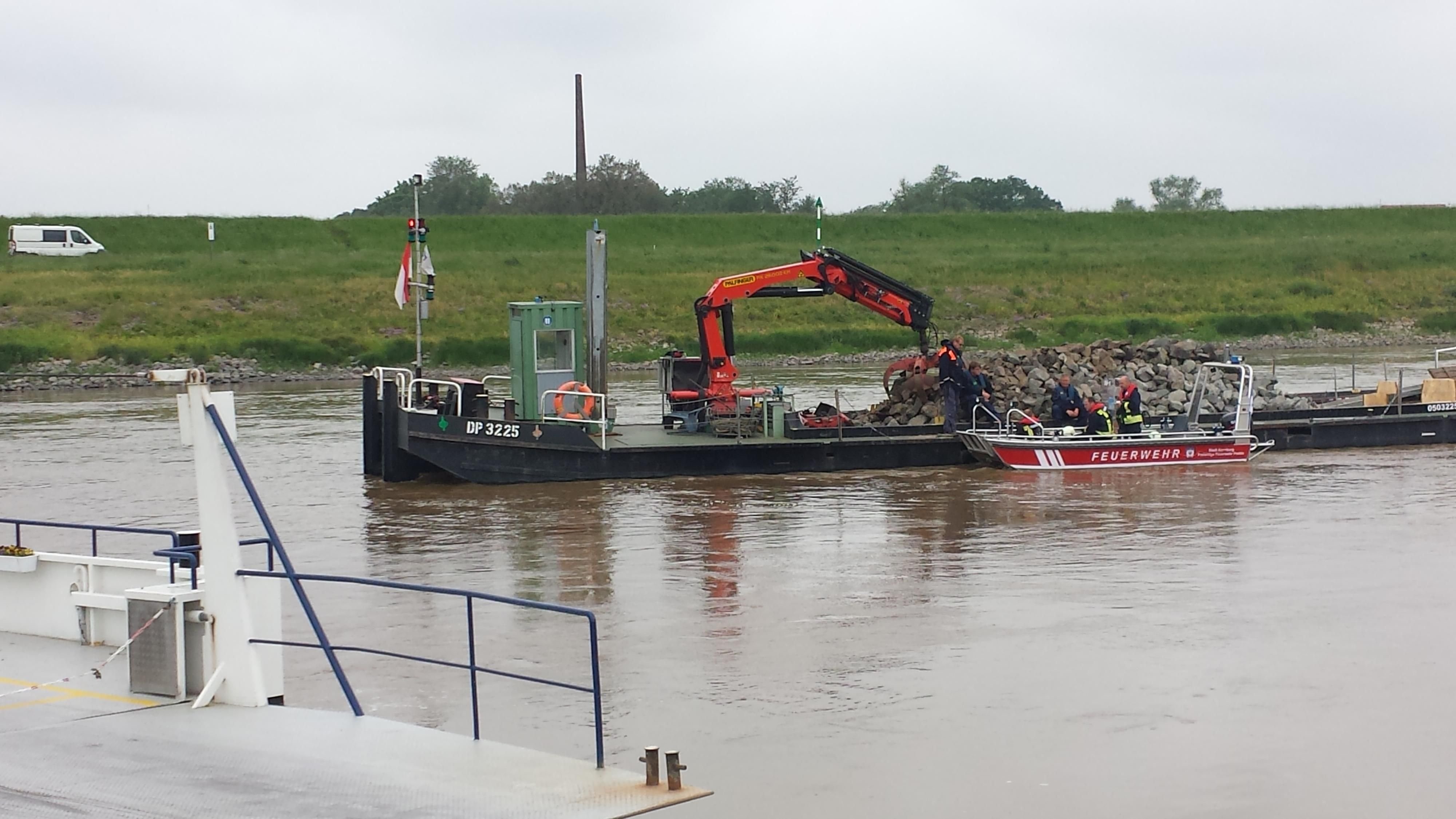 In der Nähe der Elbfähre Prettin wurde ein Arbeitsschiff so vor das Autowrack im Wasser gelegt, dass dieses nicht weiter abtreiben kann.