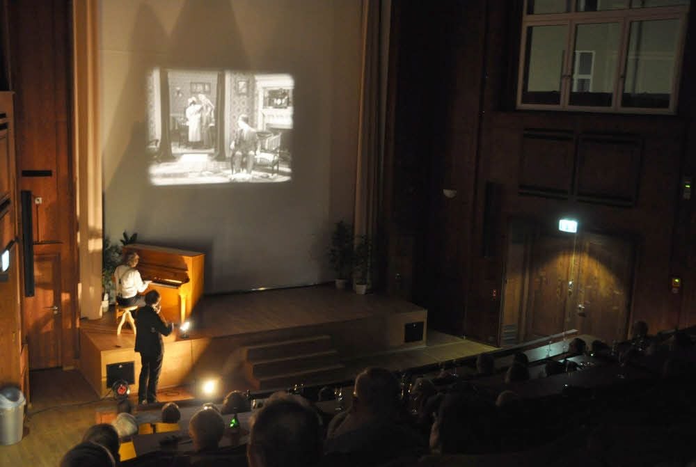 Der Hörsaal wird zum Stummfilmkino. Die beiden Musiker begleiten die drei Filme live am Klavier und auf der Geige.