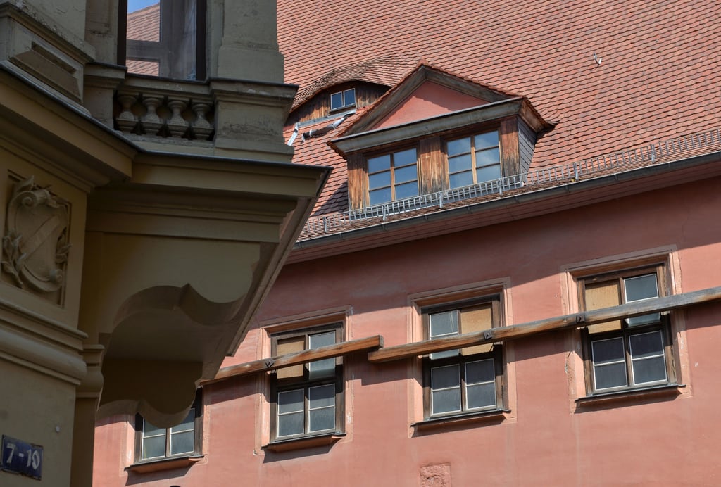 Holzbalken verschließen die Fenster eines historischen Renaissancehauses aus dem 16. Jahrhundert im Zentrum von Halle.