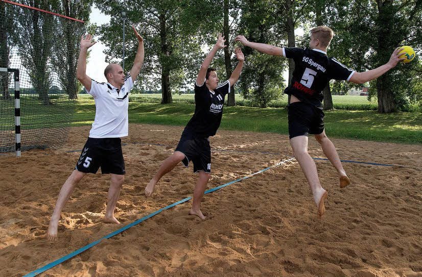 Trainer Martin Zimmermann und Max Seume wollen den Wurf von Lukas Umann (v. l.) beim Beach-Training blocken.