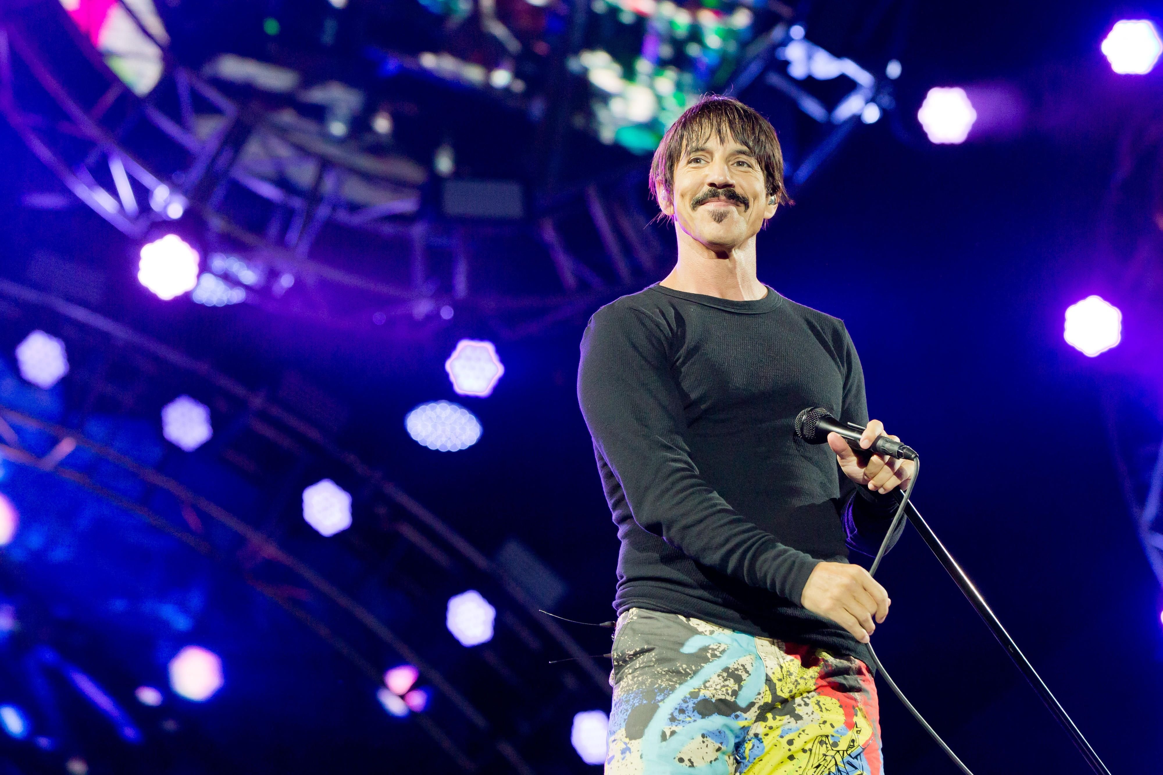 Der Frontmann der Red Hot Chili Peppers, Anthony Kiedis, steht auf der Bühne.