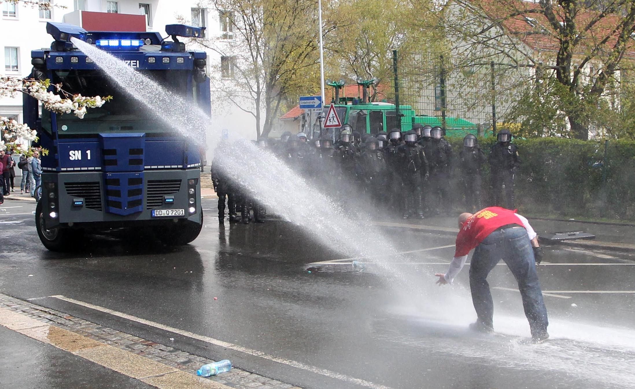 Ein Wasserwerfer der Polizei geht in Plauen gegen Teilnehmer einer rechtsextremen Demonstration vor.