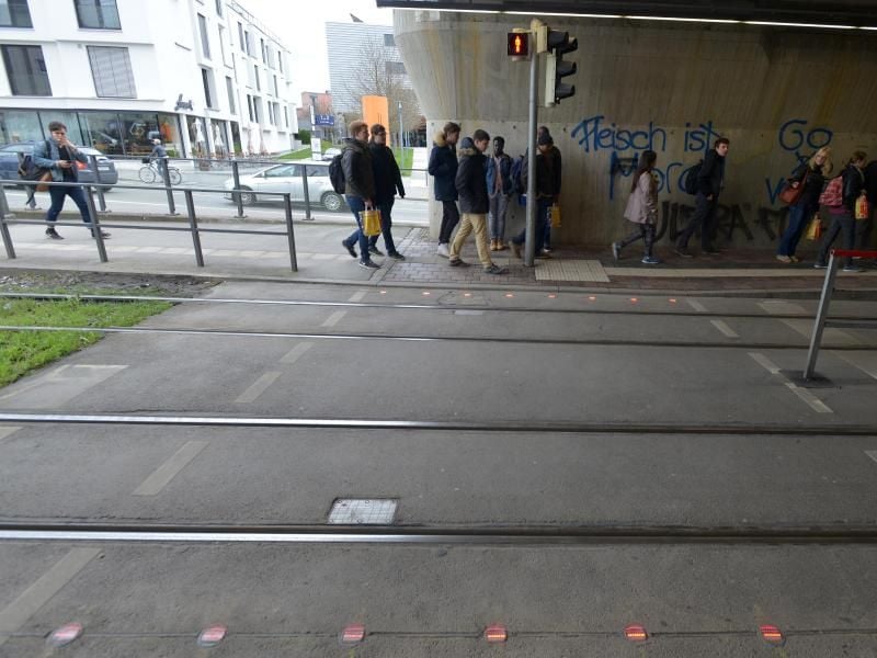 Rote LED-Leuchten entlang des Bordsteins am Übergang blinken, sobald das Fußgängersignal der Ampel auf Rot schaltet und sich eine Straßenbahn nähert. Foto: Thomas Hosemann/Stadtwerke Augsburg