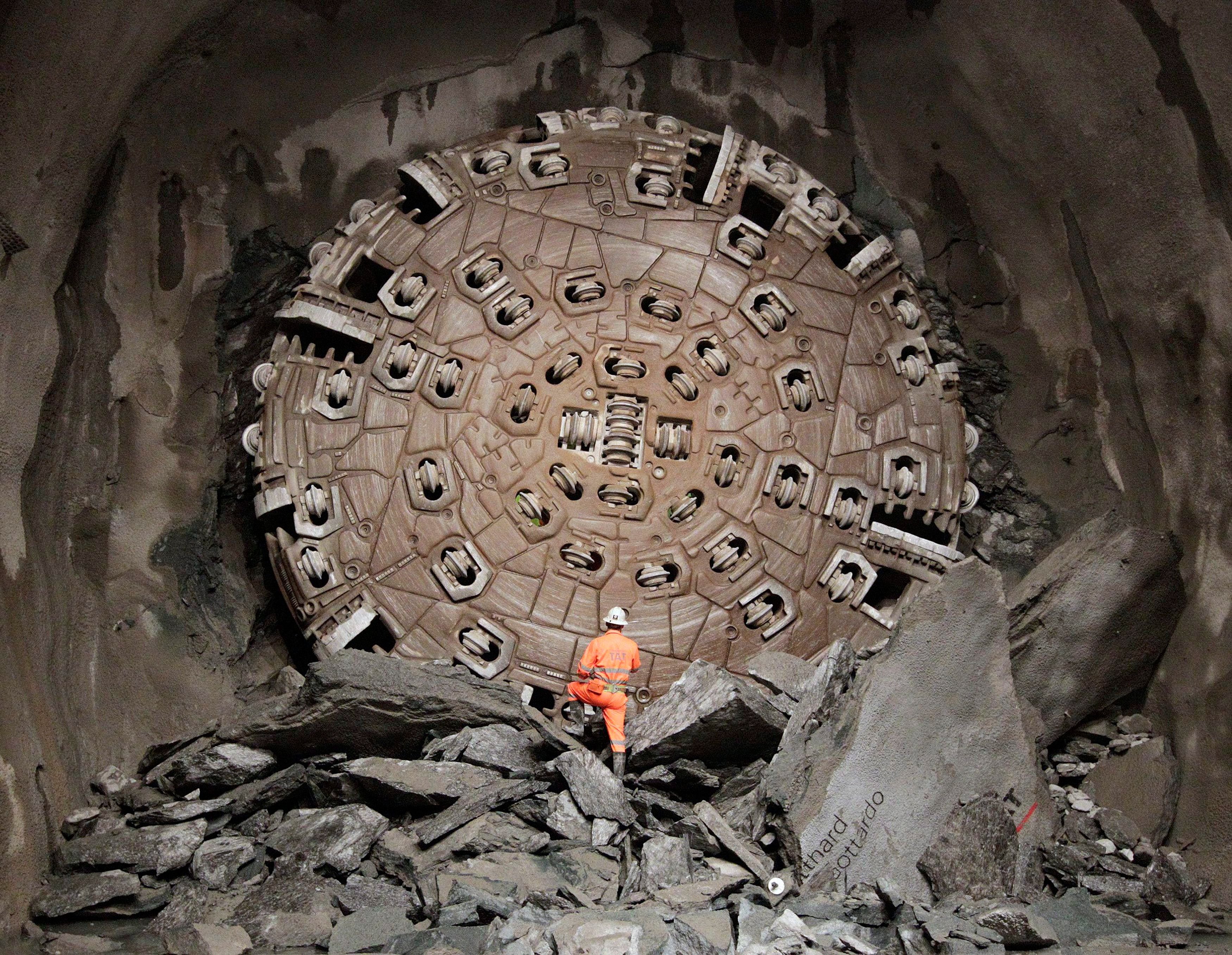 Das Foto zeigt einen Arbeiter im Oktober 2010, der den Bohrer nach dem Durchbruch im Gotthard-Basistunnel begutachtet. Mit diesem Gerät bohrten Fachleute den längsten Tunnel der Welt.