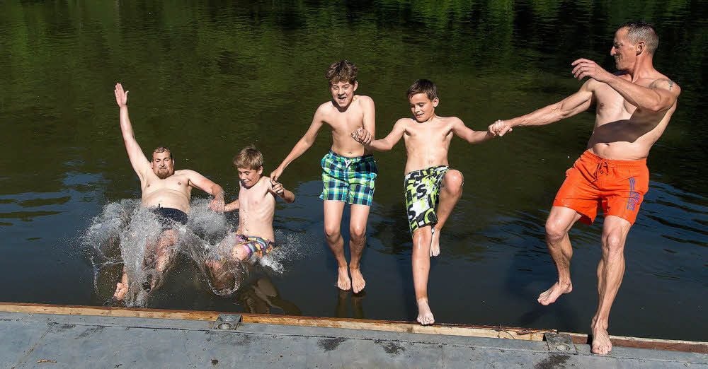Michael Hennecke (links), Niklas, Tomylee, Hannes und Heiko Neie springen vom Bootsanleger in die Saale.