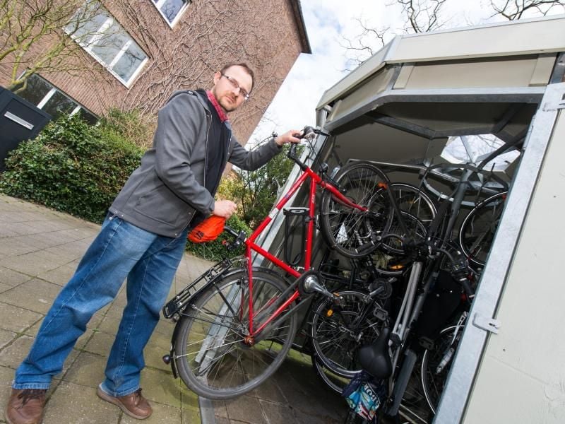 Matías Steinigk parkt sein Fahrrad in einem Fahrradhaus in Düsseldorf. Die Garagen für Fahrräder erfreuen sich immer größeren Beliebtheit. Foto: Monika Skolimowska