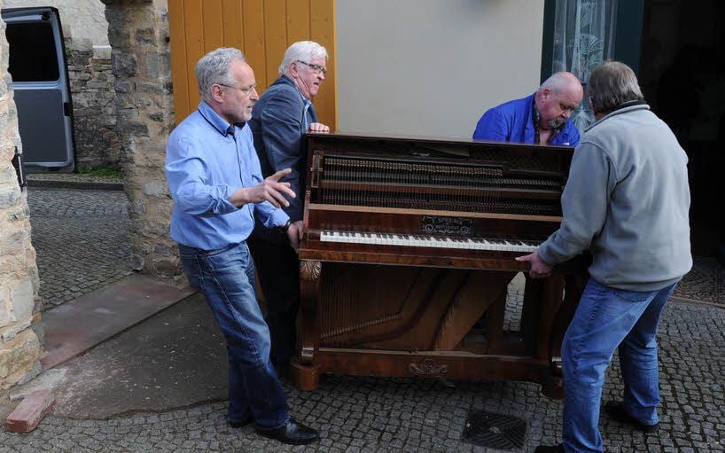 Vier Männer mussten viel Kraft aufwenden, um das Klavier an seinen Platz in der „Historischen Druckerei Heise“ zu bringen.