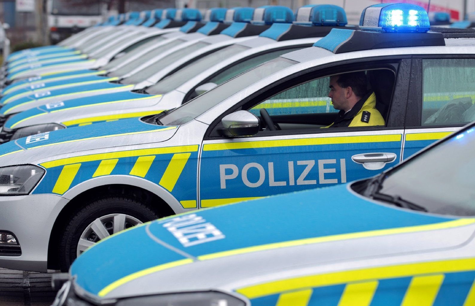Ein Polizeibeamter sitzt in einem Streifenwagen der Polizei.